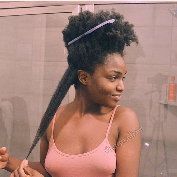 Femme aux longs cheveux afro qui étire une mèche